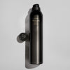 Oribe hairspray bottle beside cap