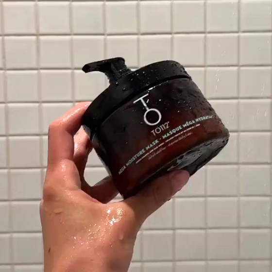 Hand holding TO112 Hair Mask in Shower