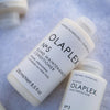 two bottles of white hair products lying diagonally