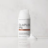 white bottle with gold band of hair product